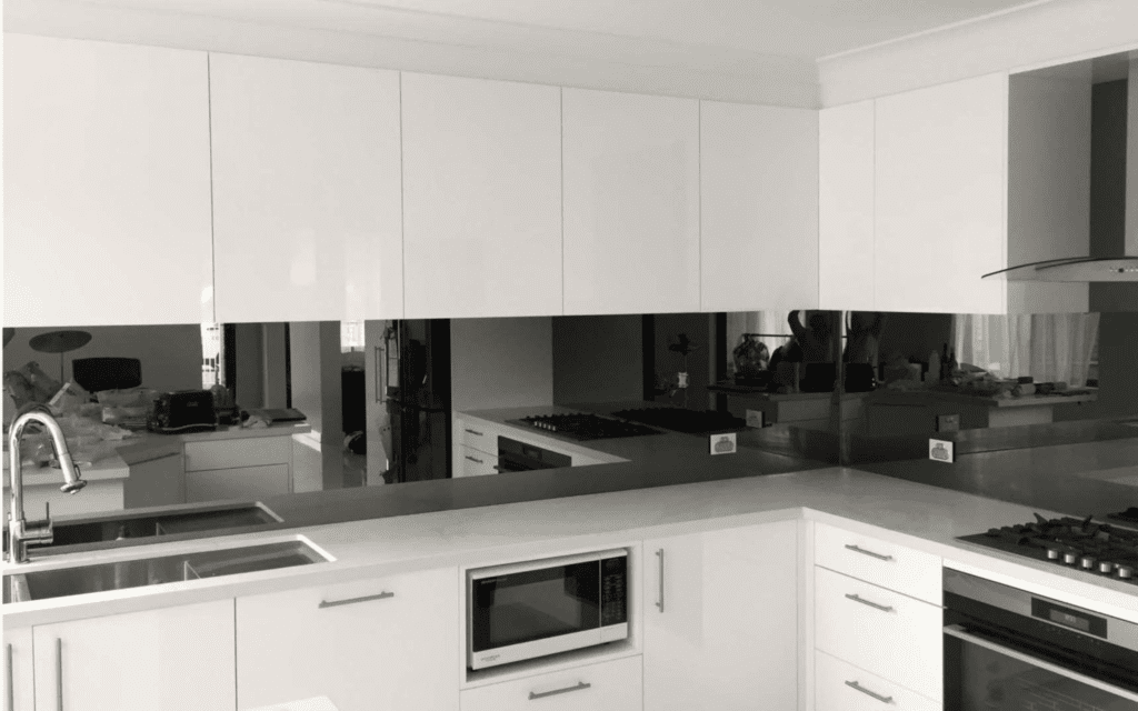 smoked mirror splashback with white cabinets