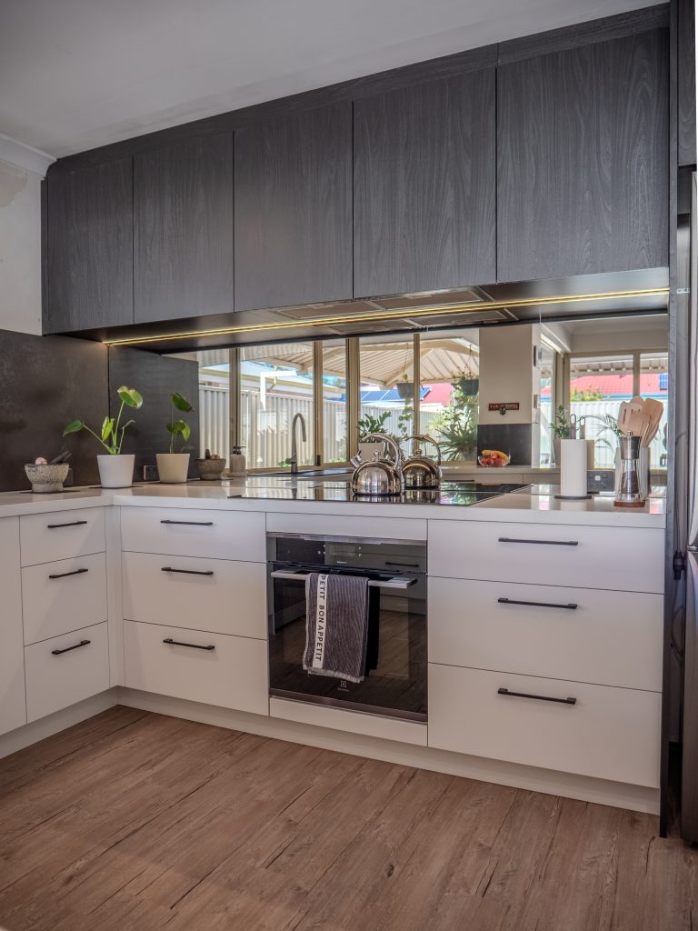 dark mirrorrf splashback in a Perth kitchen with dark timber overhead cabinets and white drawers
