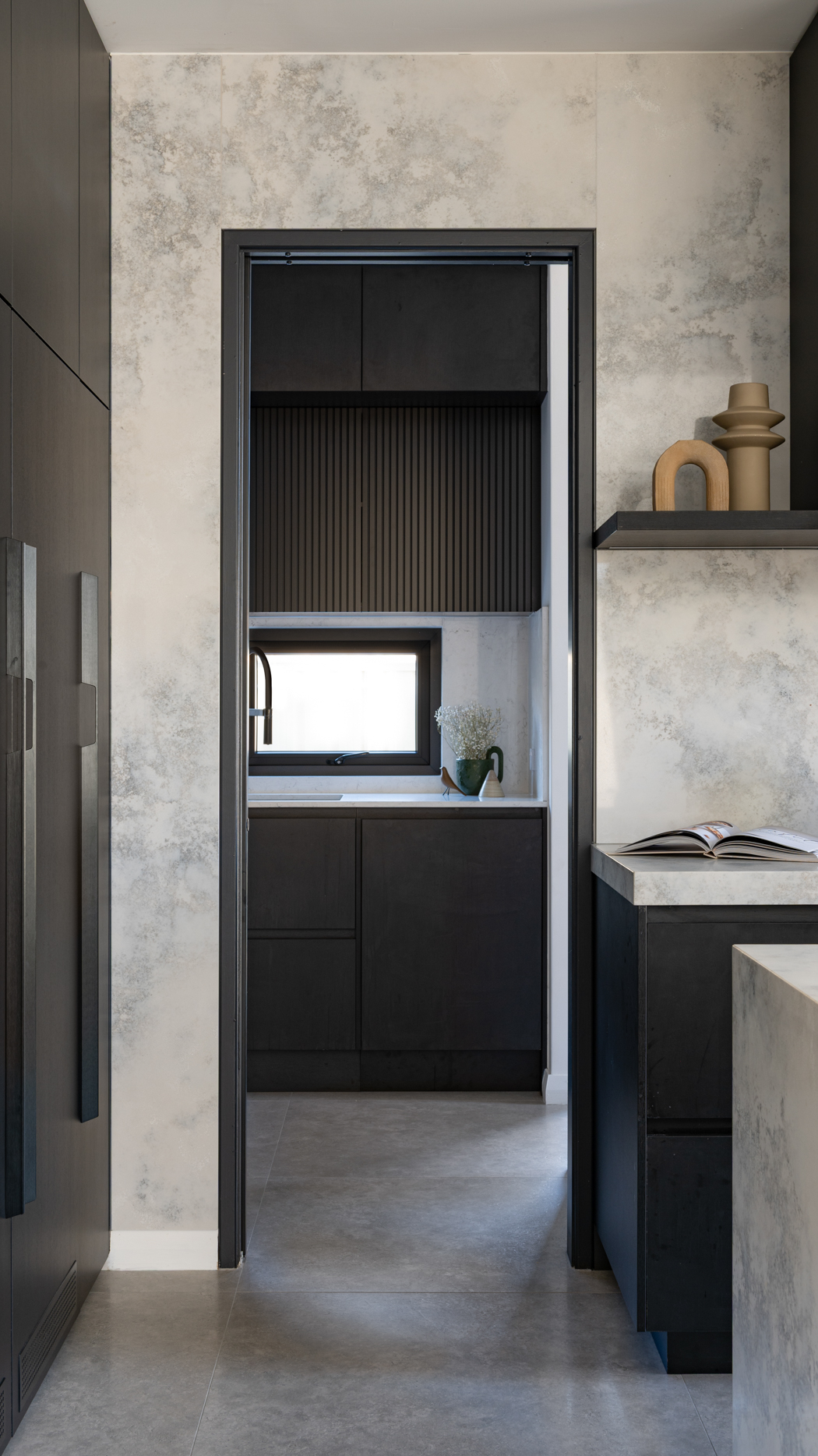 Stone splashback wrapping around the doorway into a black scullery